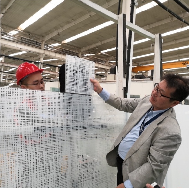 Japanese architects inspect glass in factory-morn
